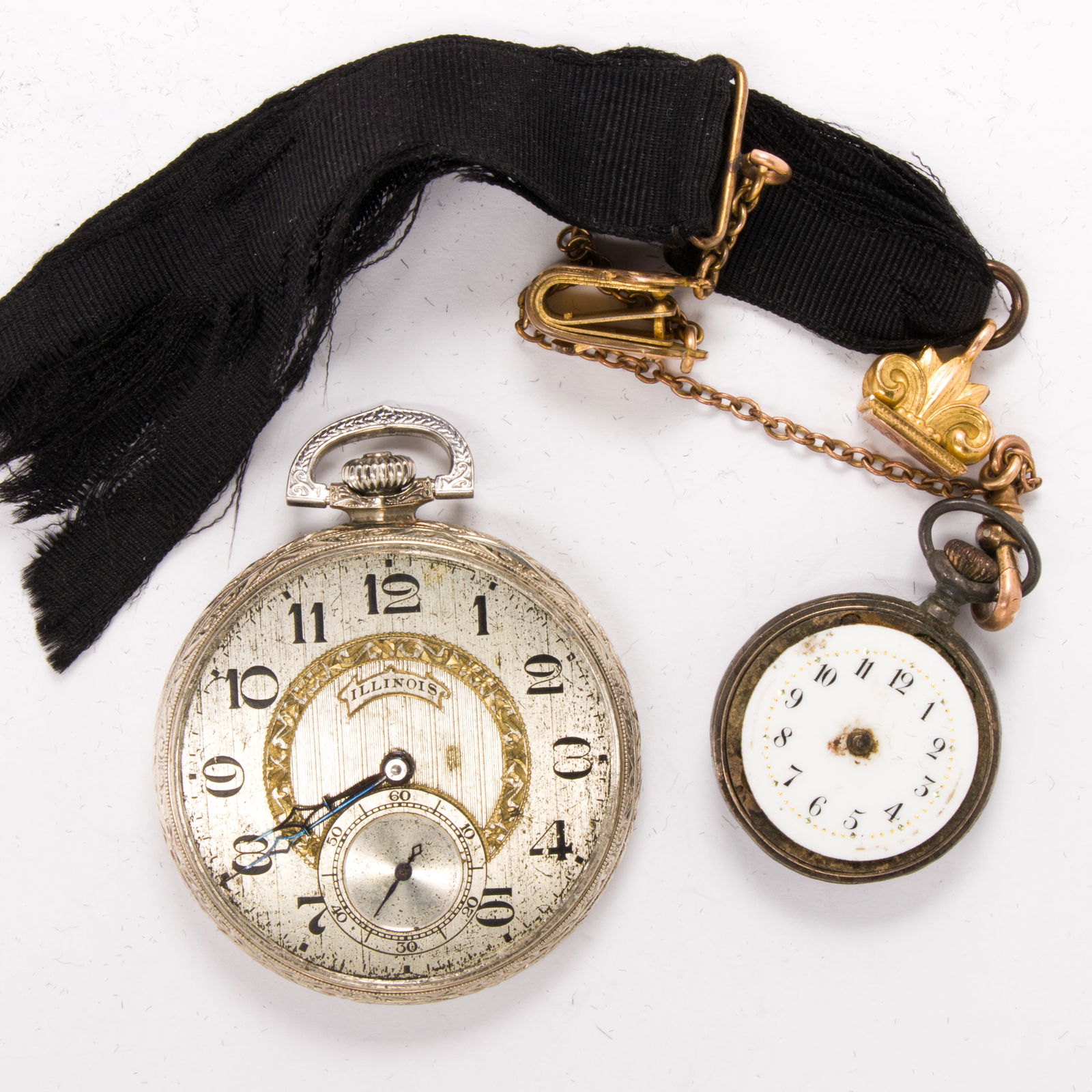 Two antique pocket watches: Two antique pocket watchesOne featuring watch chain and ribbon fob, together with one of silver-tone gold fill; gross weight: 77.10 grams Condition note: each missing crystal