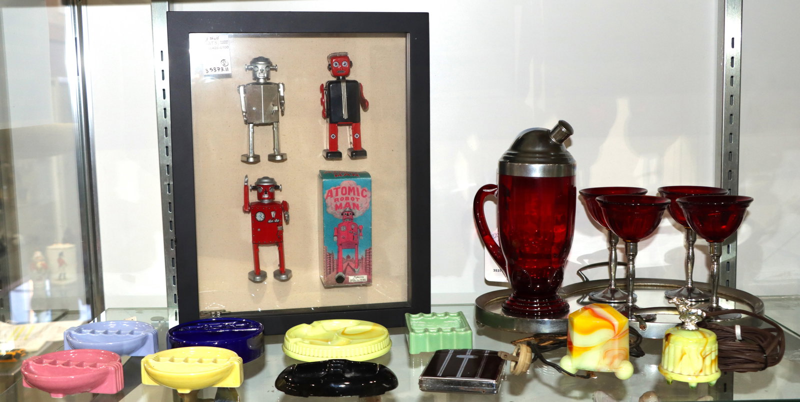 A collection of Art Deco and Art Deco style Decorations: A collection of Art Deco and Art Deco style decorations, comprising (1) 6 piece chromed metal and ruby glass martini set; (1) Ronson enameled combination lighter and cigarette case; (6) Snuff-a-rette