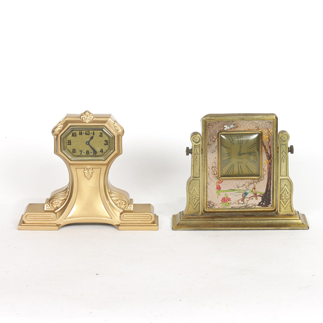 Two American Art Deco table clocks: Two American Art Deco table clocks, circa 1930s, the first Nuart enamel decorated clock hinging within frame, 7.5"h; the second Lux Clock Company gilt metal clock, 8"h