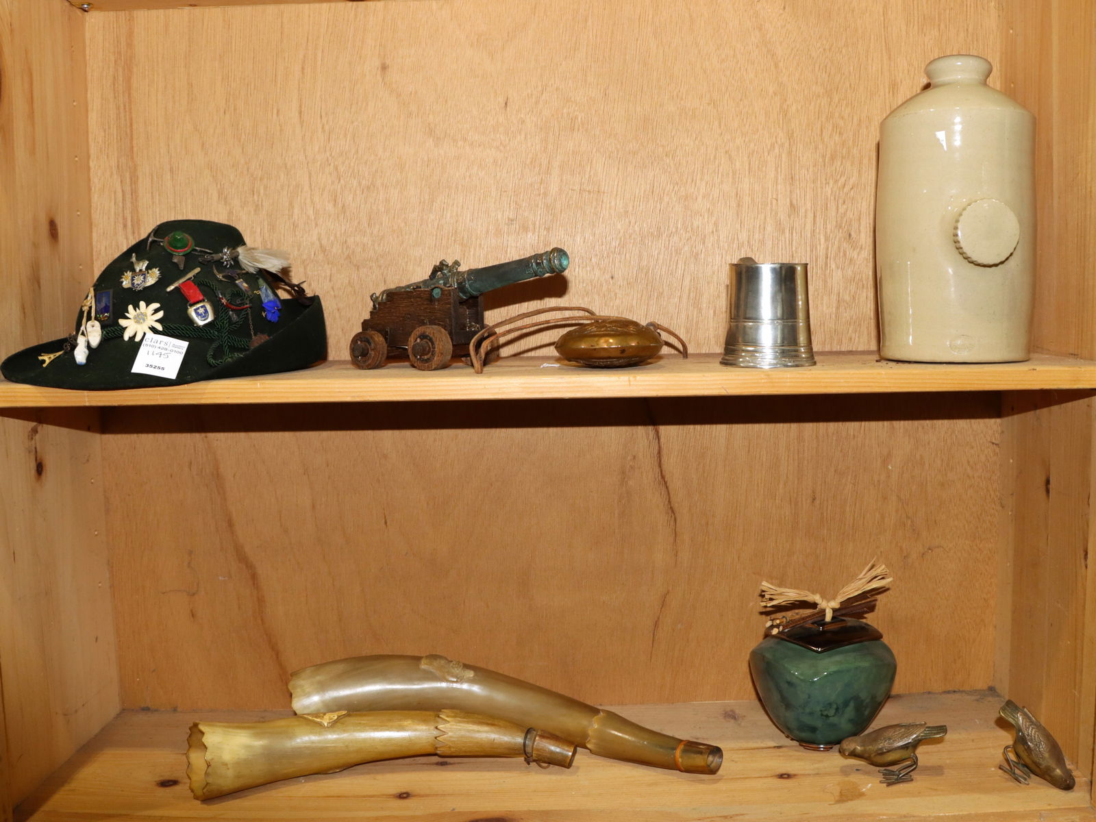 An alpine hat with badges and other items: An alpine hat with badges and other items, comprising (1) green felt child's hat by Gunzrodt-Hute with (approx 15) various pins; (1) miniature cannon; (1)powder flask embossed with game scenes; (2)