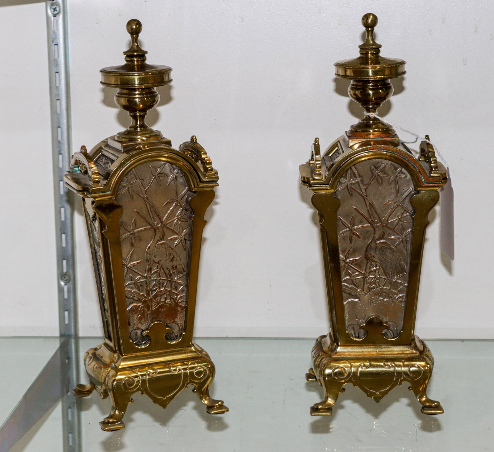 A Pair of Aesthetic Movement Brass and Silvered Mantel Garnitures: A pair of Aesthetic Movement brass and silvered mantle garnitures, the silvered inset panels depicting herons, 12.5"h x 4.5"w x 4"d