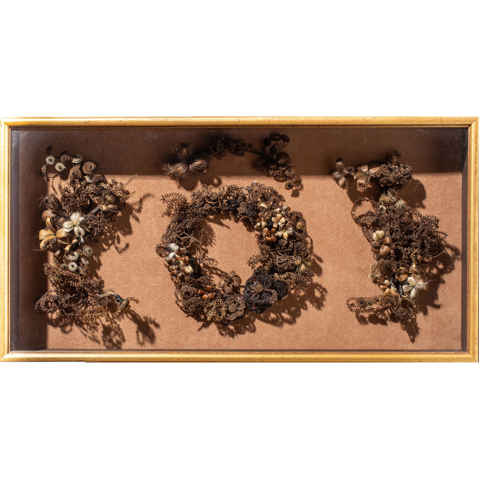 A Victorian Hair Picture: A Victorian hair picture, late 19th century, the floral wreath flanked by a bouquet on either side, later mounted in shadowbox frame, overall 14"h x 27.25"w x 3.25"d
