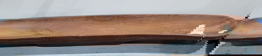 An Oceanic carved wood long bowl: An Oceanic carved wood long bowl, Tahiti, carved in the Marquesan style, signed 'Ahlo Leon, 1980, Tahiti', 4"h x 42.75"l