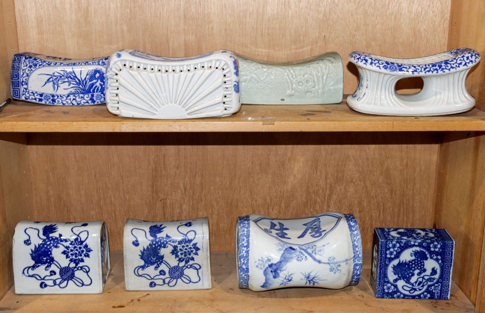 (lot of 8) Blue and white and celadon glazed head rests: (lot of 8) Blue and white and celadon glazed head rests. 20the century, 9" widest.