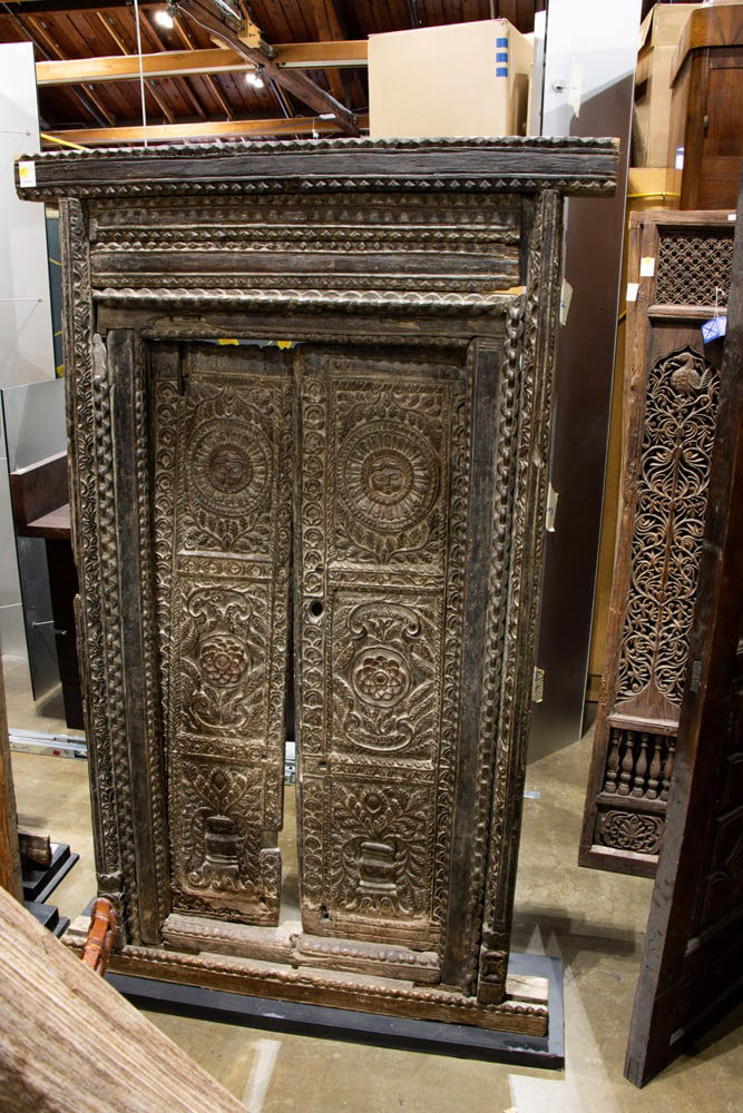 A Nepalese carved wood door: A Nepalese carved wood door. Newari, modern stand, 18th century, 69"h x 42.5"w.