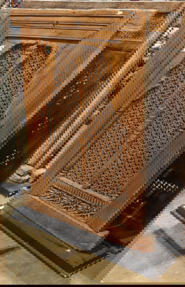 An Indian carved and pierced wood window panel: An Indian carved and pierced wood window panel. 18th century, modern metal stand, 50"h x 40"w excluding stand.