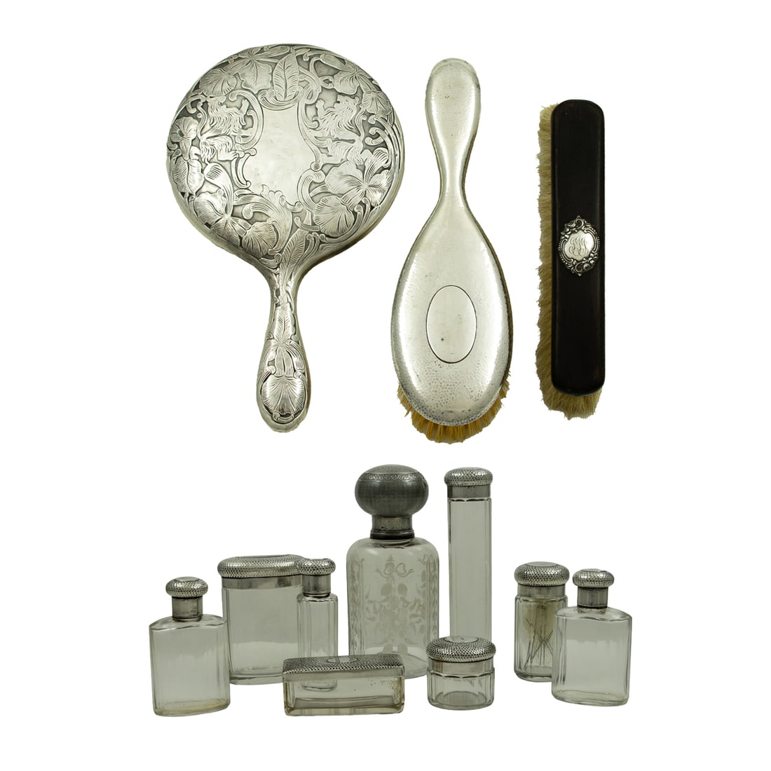 A group of sterling and glass toiletry items: A group of sterling, 950-standard silver, and 800-standard silver-mounted glass and ebony toiletry articles, comprising (8) glass bottles and containers with 950 standard silver covers, 1.5"-7"h; (1)