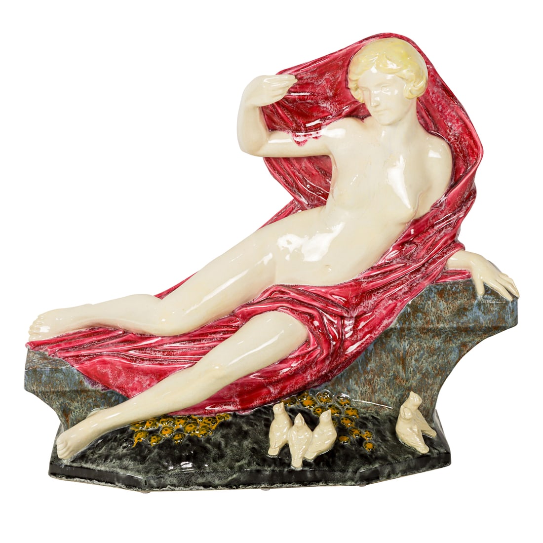 An Art Deco glazed pottery ceramic of a female nude: An Art Deco glazed pottery ceramic of a female nude, circa 1930, depicted reclining on a bench dressed only in red drape, small birds at the base, unmarked, 18"h x 21"l