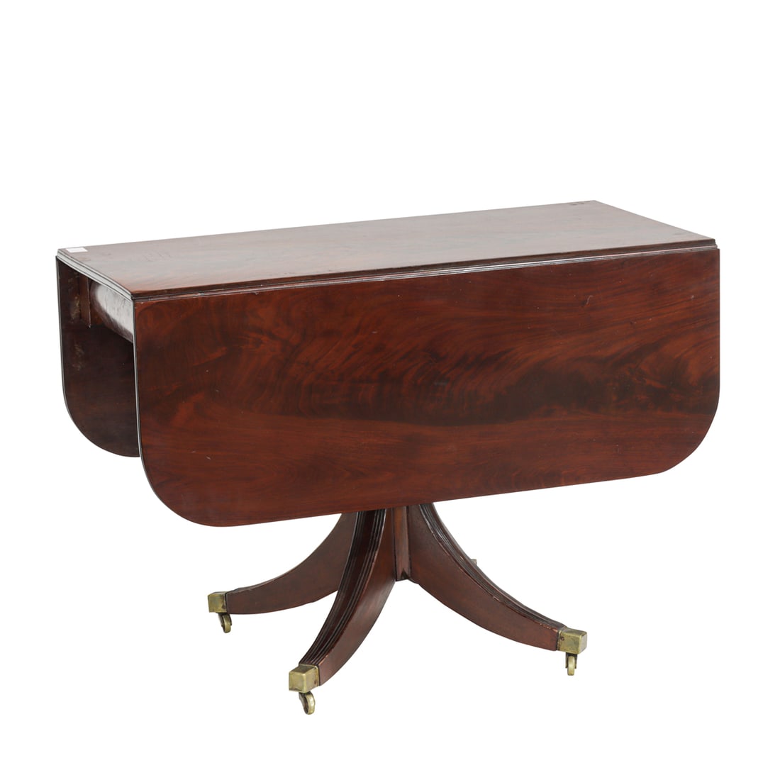 A Regency flame mahogany drop-leaf breakfast table: A Regency flame mahogany drop-leaf breakfast table, early 19th century, the rectangular top with rounded corners, raised on turned pedestal with four fluted legs terminating in brass capped feet with
