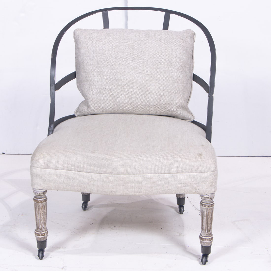 A Restoration Hardware (RH) Couturier's chair: A Restoration Hardware (RH) Couturier's chair, the exposed metal frame back over shaped linen upholstered seat, raised on fluted legs ending in casters, include throw pillow, 30.5"h x 23.5"w x 22.5"d