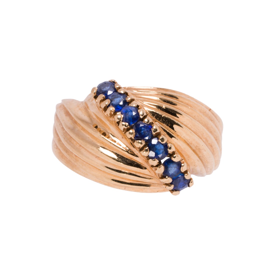 A sapphire and 14k gold ring: A sapphire and 14k gold ringSet with a row of seven round-cut blue stones; size 9; 6.25 grams