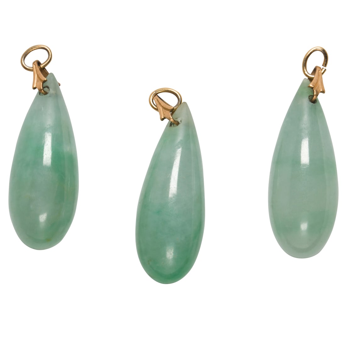 Three jade and 10k gold pendants: Three jade and 10k gold pendantsComprising three jade drop pendants measuring approximately 23.85 x 9.44 mm, set with 10k gold bails; gross weight: 10.10 grams