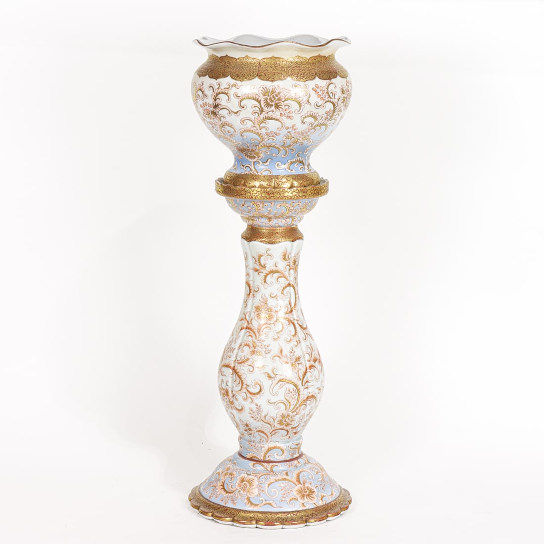 A Kutani pedestal jardiniere: A Kutani pedestal jardiniere. The lobed upper bowl with foliate rim above a baluster-form pedestal and flared base, featuring scrolling floral motif, Meiji period, 29.125" high.