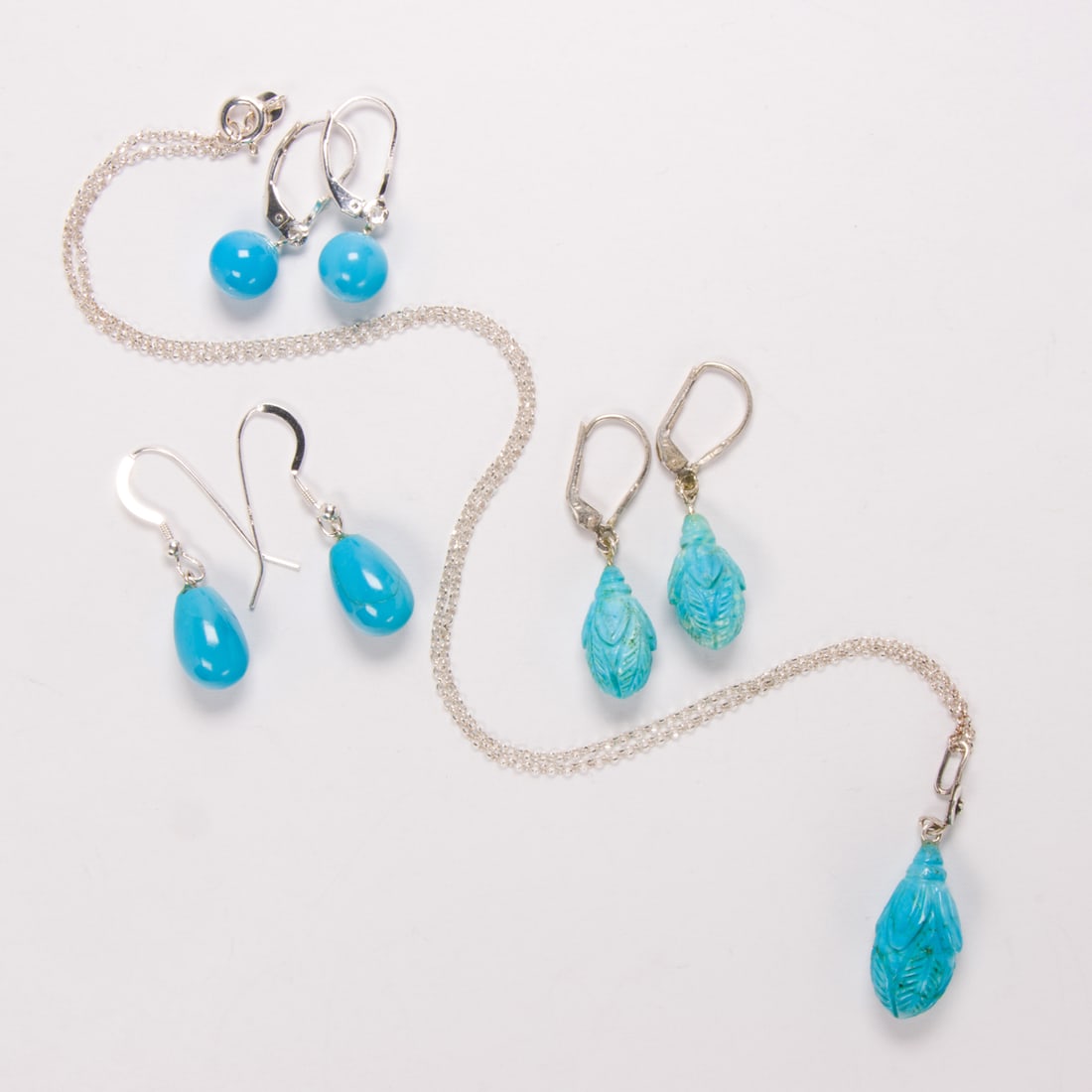 A miscellaneous group of turquoise and silver jewelry: A miscellaneous group of turquoise and silver jewelryComprising three pairs of earrings and one pendant necklace of varying styles; gross weight: 13.10 grams
