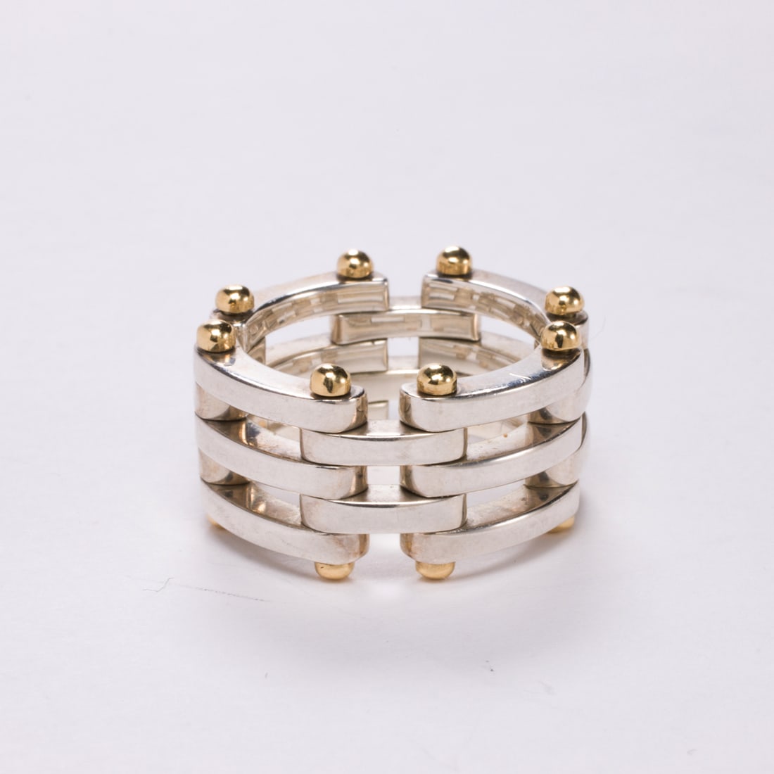 A Tiffany & Co. sterling silver and 18k gold ring: A Tiffany & Co. sterling silver and 18k gold ringOf gatelink design, featuring sterling silver links with 18k gold findings; size 5 1/2; 11.30 grams