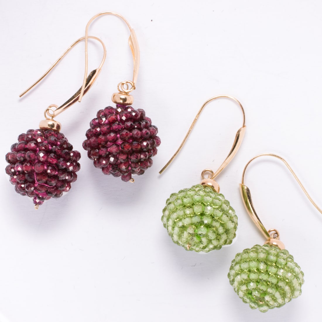 Two pairs of peridot and garnet 14k gold earrings: Two pairs of peridot and garnet 14k gold earringsEach of beaded ball form design; length: 1 1/4 in; length: 1/3 in; 8.90 grams
