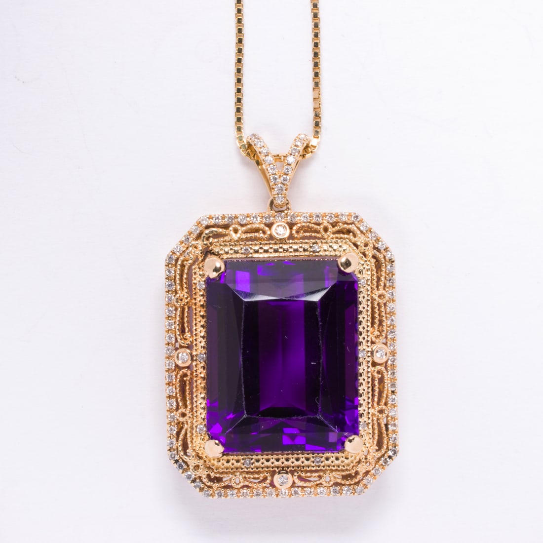 An amethyst, diamond, and 14k gold pendant necklace: An amethyst, diamond, and 14k gold pendant necklacecentering a rectangular step-cut amethyst measuring approximately 19.00 x 15.00 x 11.33 mm, within filigree mounting accented by round brilliant-cut