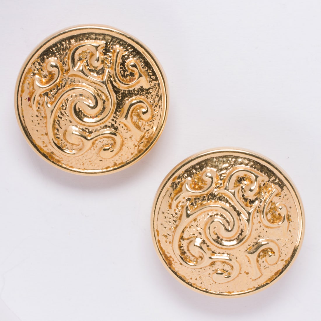 A pair of 14k gold earrings: A pair of 14k gold earringsDesigned as hollow-form discs accented by textured scrolling; length: 1 1/8 in; 8.05 grams