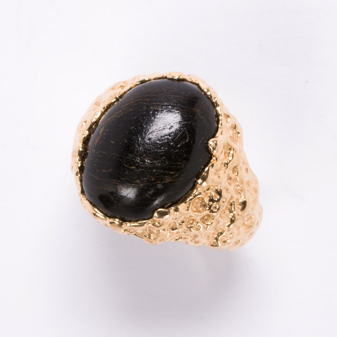 A Koa wood and 14k gold ring: A Koa wood and 14k gold ringFeaturing an oval-shaped Koa wood cabochon set within textured 14k gold; size 8; 7.65 grams