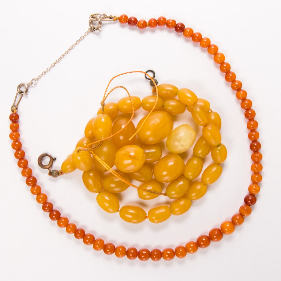 An amber group: An amber groupComprising one amber necklace designed with round shaped amber beads measuring 5.41 mm, together with a group of oval-shaped amber beads; necklace length: 15 1/2 in; gross weight: 39.45