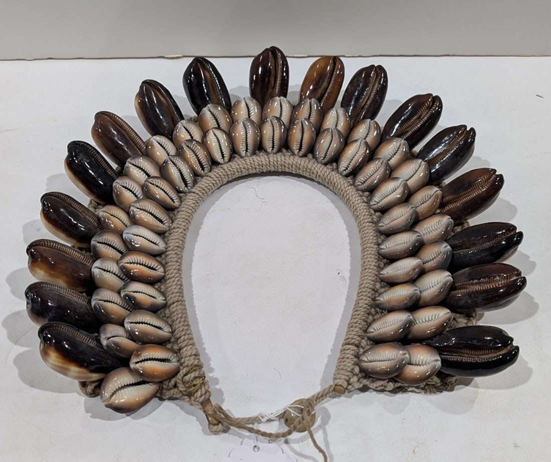 A Cowrie shell necklace on fiber backing: A Cowrie shell necklace on fiber backing, 11.5"h x 12.5"w