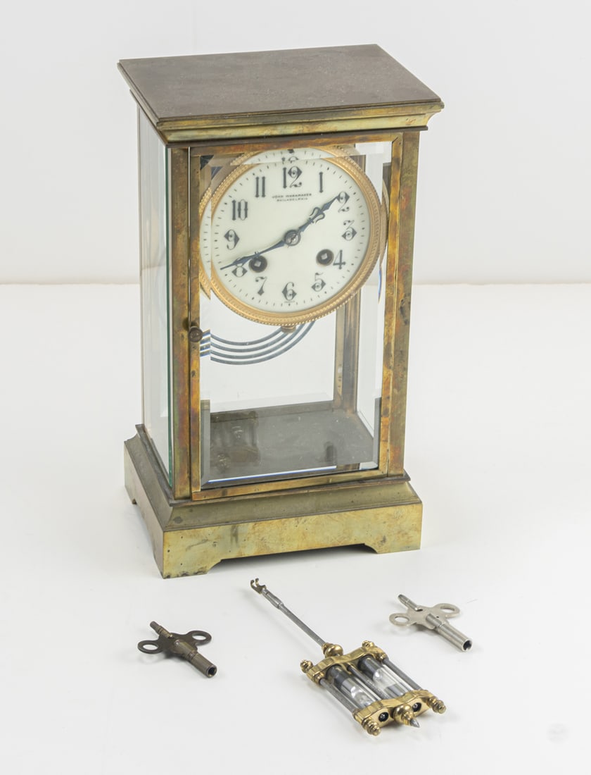 Two mantel clocks: Two mantel clocks, the first gilt bronze four-glass example in the Gothic Revival style retailed by Rand & Crane, Boston, 11.75"h; the second anniversary clock beneath glass dome, overall 12"h