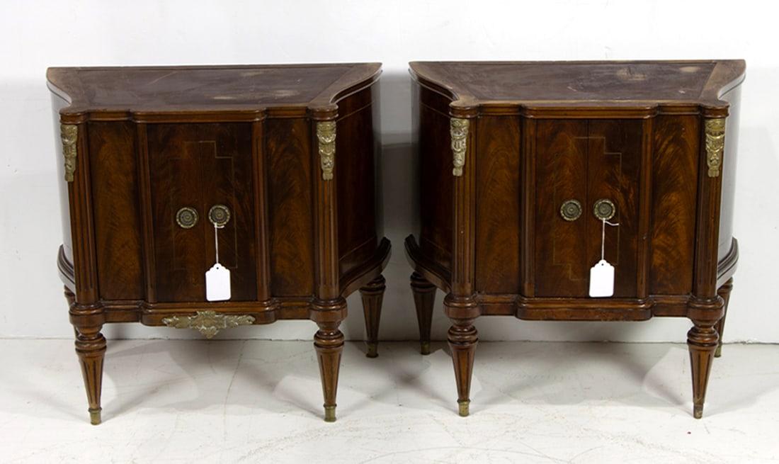 A pair of Louis XVI style gilt bronze mounted bedside cabinets: A pair of Louis XVI style gilt bronze mounted bedside cabinets, each shaped top over two engaged columns centering two doors and enclosed drawer, 25"h x 26"w x 15"d