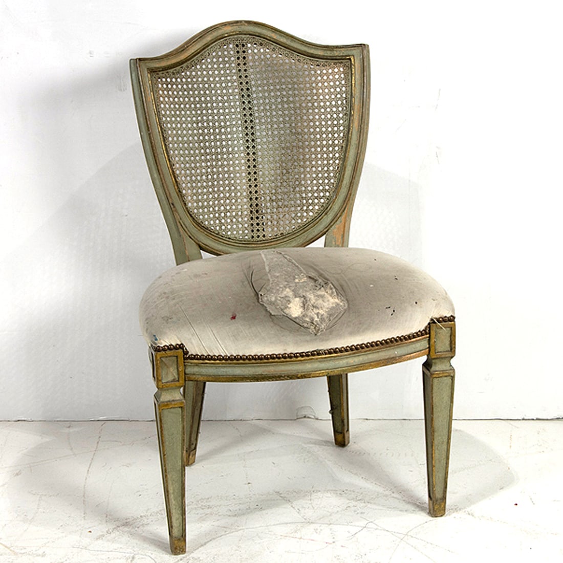 A William Switzer polychrome and parcel gilt dining chair in the Neoclassical taste: A William Switzer polychrome and parcel gilt dining chair in the Neoclassical taste, featuring shield shaped cane back, 37"h x 23"w x 19.5"