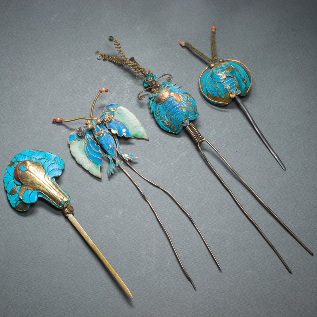 (lot of 4) Chinese kingfisher feather hair pins: (lot of 4) Chinese kingfisher feather hair pins. of Tian-Tsui design with contemporary alterations, including four hair pins in the form of butterfly, flower or insect, set with jade, carnelian or bea