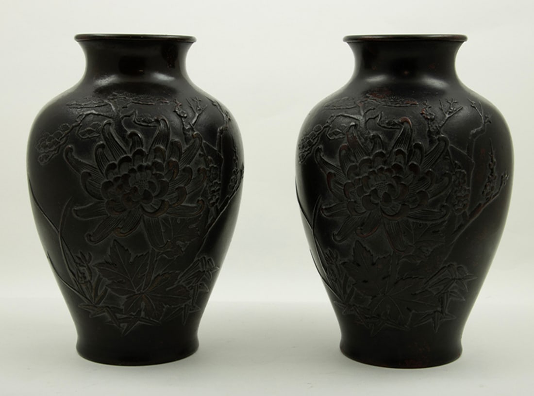 (lot of 2) Japanese pair of bronze vases: (lot of 2) Japanese pair of bronze vases. With short slightly flared neck above ovoid body, with molded chrysanthemums, plum blossom branches, pine tree, orchid and bamboo, 8.75"h. Provenance: Clars s