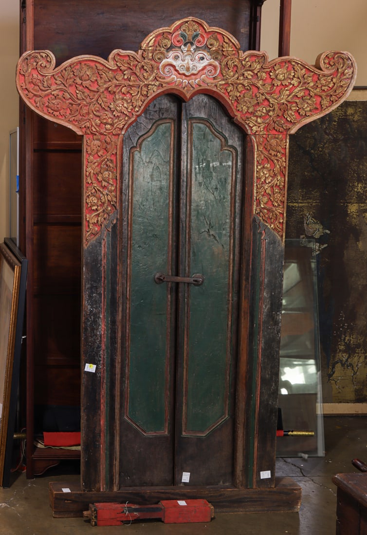 A Balinese painted and carved wood door: A Balinese painted and carved wood door. With Makara and painted in green and red, 19th century, 81"h x 55.5"w. Provenance: ex Spink, London - purchased on May 29, 1985.