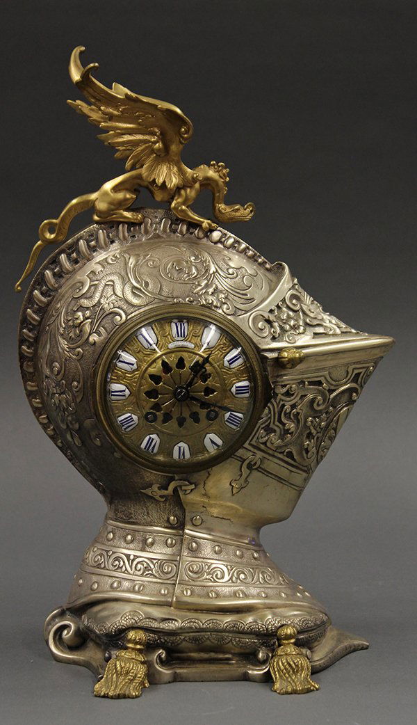 French mantle clock: French mantle clock, late 19th century, the decorated case in the form of a knights helmet, surmounted with a gilt bronze winged griffin finial above the silvered case accented with scroll and vine re
