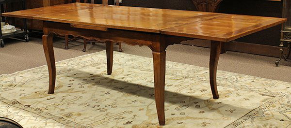 French Provincial draw leaf table: French Provincial draw leaf table, 19th century. Having a framed plank top and shaped skirt resting on cabriole legs. 28"h x 94"w 36"d.