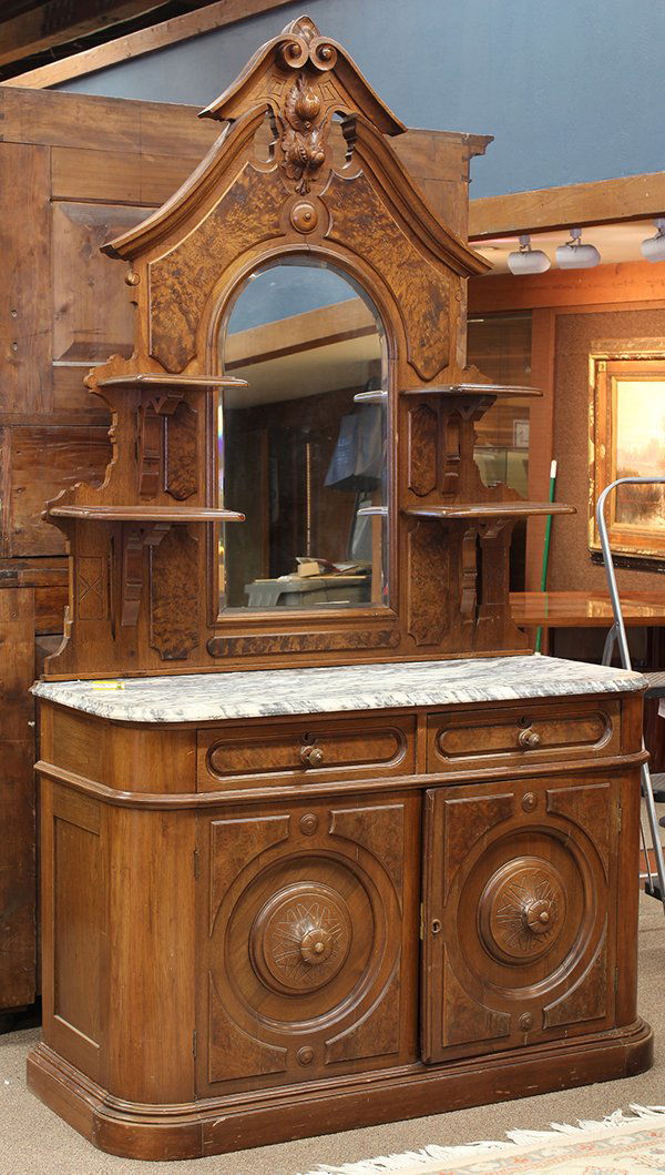 American Victorian walnut sideboard: American Victorian walnut sideboard, Grand Rapids circa 1860, the superstructure with a naturalistic medallion flanked with raised burl panels surmounting the shaped looking glass terminating at the l