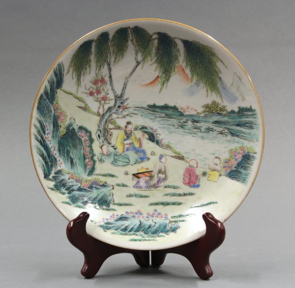 Chinese Porcelain Plate, Figures: Chinese enameled porcelain plate, featuring scholars enjoying tea on a river bank while an attendant tends to a kettle of water, the base with an apocryphal Qianlong mark, 9.25"w