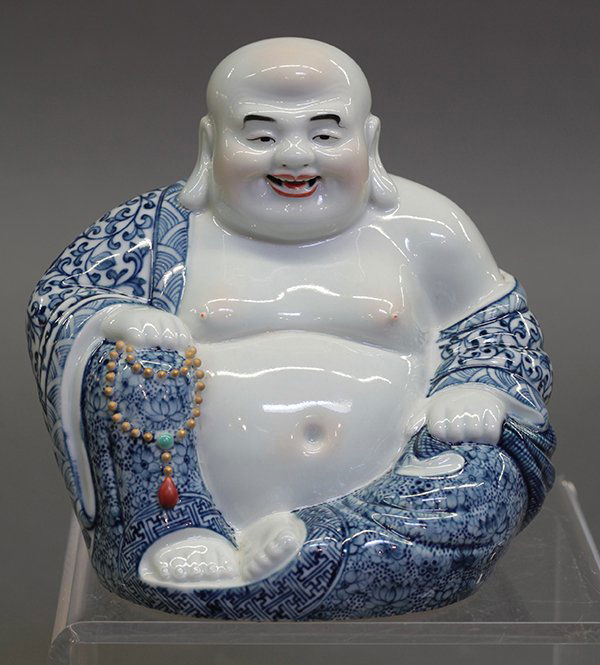 Chinese Small Porcelain Budai: Chinese enameled porcelain Budai, the bodhisattva seated in royal ease draped in a blue-and-white robe, while clutching prayer beads and a sack, the base impressed 'Wei Hongtai zao', 5.5"h