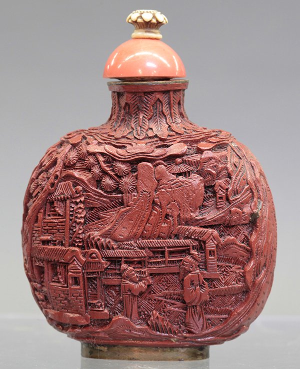 Chinese Cinnabar Snuff Bottle: Chinese cinnabar hue snuff bottle, the flattened circular body featuring a scene with figures standing beside a pavilion complex, bottle: 3.25"h