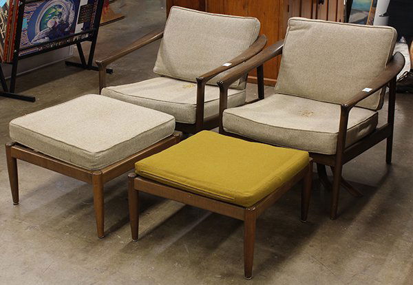 Pair of Folke Ohlsson lounge chairs: (lot of 7) Two pairs of Folke Ohlsson lounge chairs and three matching ottomans for Dux of Denmark. Low slung arm chairs of oak with teak arms, spindle back rest and rubber and leather strap seat supp