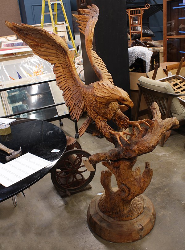 Carved Bald Eagle sculpture: Carved Bald Eagle sculpture, the carved form depicted in motion, its wings spread and landing on a tree limb, overall 58"h x 24"w