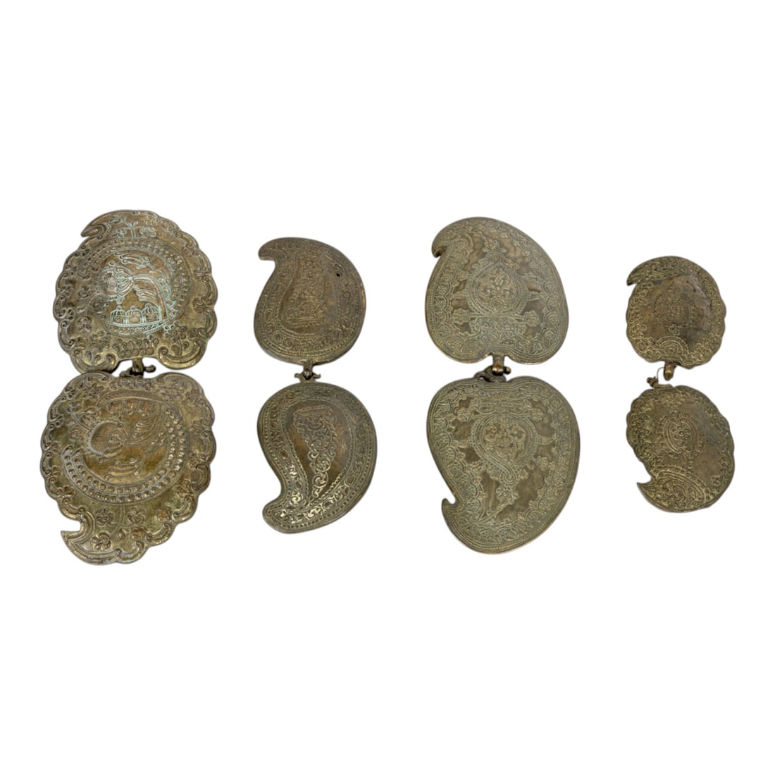 A group of four Ottoman metal belt buckles (pafti): A group of four Ottoman metal belt buckles (pafti), 19th century, each of leaf form with repousse stylized foliate scrolls, (4) greatest 5.5"l x 4.5"w; (4) smallest 3.5"l x 2.5"w. Note: Proceeds from
