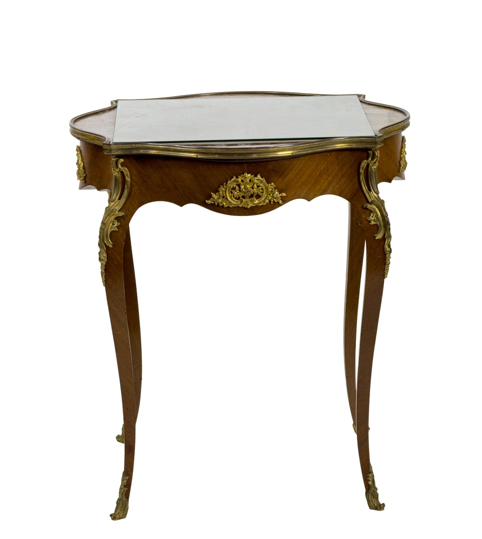 A French gilt mounted gueridon circa 1900: A French gilt mounted gueridon circa 1900, the shaped captured marble top above the conforming base having gilt mounts and rising on cabriole legs terminating on sabots, 30"h x 27"dia