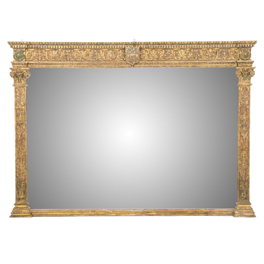 A Renaissance Revival style polychrome and gilt overmantel mirror: A Renaissance Revival style polychrome and gilt overmantel mirror, the foliate carved freize centering shield, flanked by engaged columns and centering a mirror plate, 50"h x 71"w x 3"d