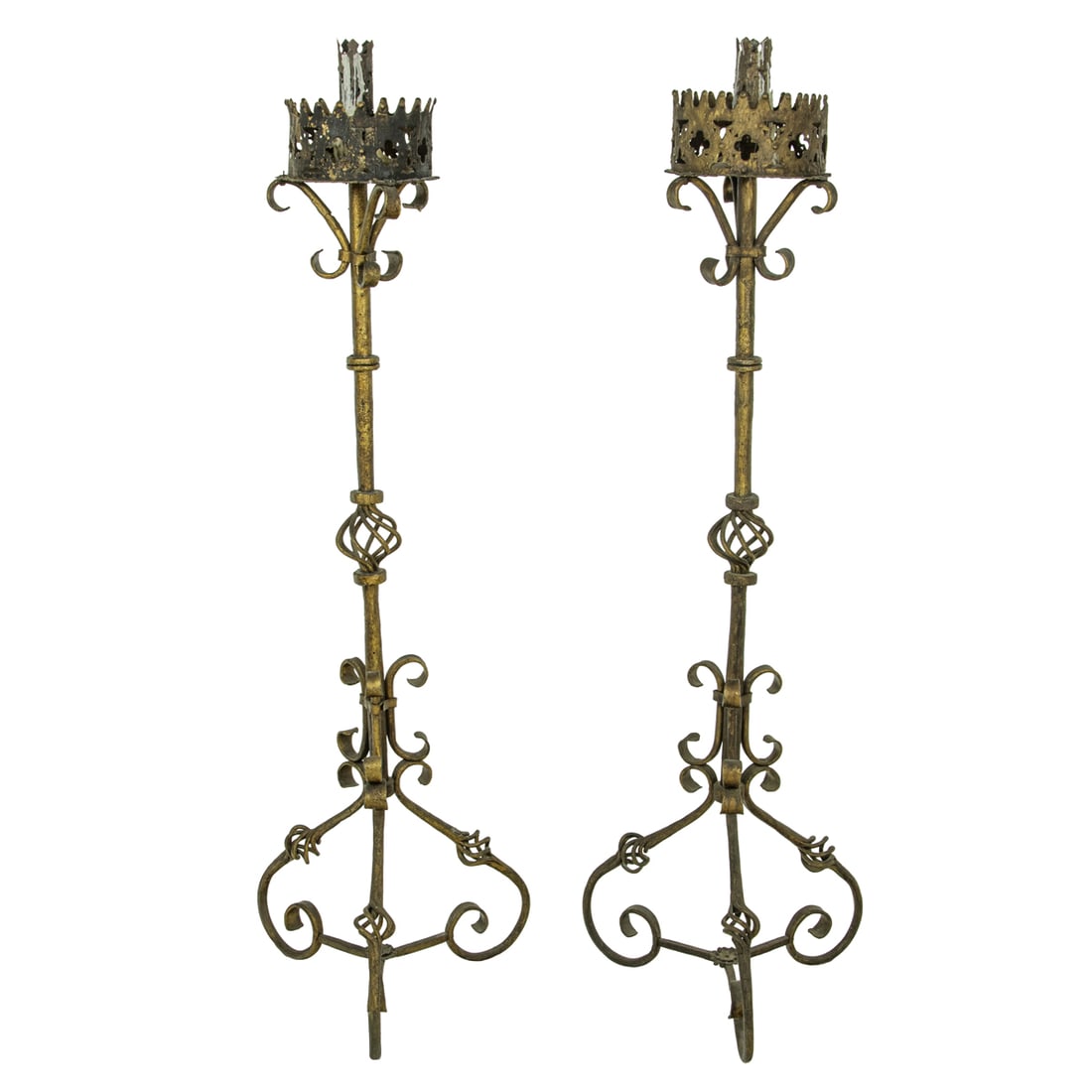 A pair of Spanish hand wrought metal candle stands circa 1900: A pair of Spanish hand wrought metal candle stands circa 1900, with a pierced top with quatrefoil reserves surrounding the large candle holder, and resting on a tripartite base, 59"h x 19"w