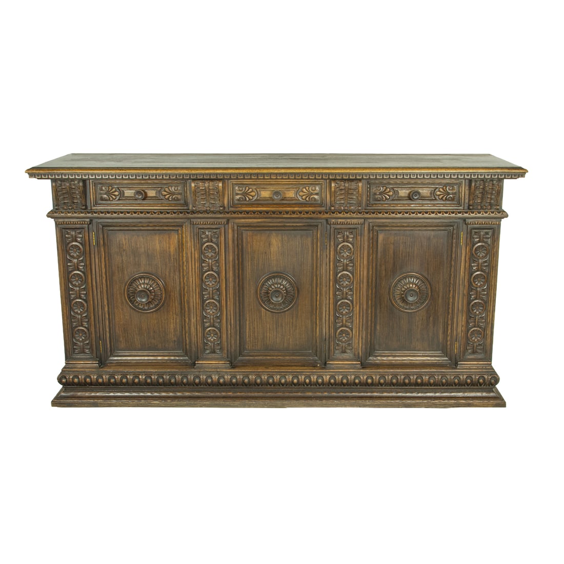 A Spanish Revival buffet circa 1920: A Spanish Revival buffet circa 1920, the highly carved case with rosette and leaf reserves flanking the three drawers, and rising on carved paw feet, , 41"h x 74"w x 24"d