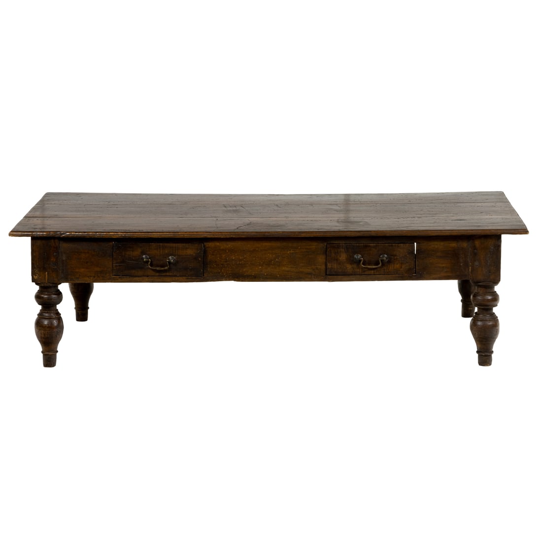 A large Indonesian low table in the Spanish Colonial style: A large Indonesian low table in the Spanish Colonial style, the plank top over freize with two drawers, raised on turned legs, applied 'Made in Indonesia' label, 18"h x 66.5"w x 31"d