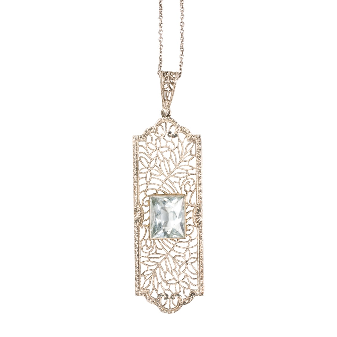 An Edwardian style aquamarine and 14k white gold pendant necklace: An Edwardian style aquamarine and 14k white gold pendant necklace Of open-form filigree style, centering a princess-cut aquamarine weighing approximately 2.75 carats, on cable-link chain; pendant leng