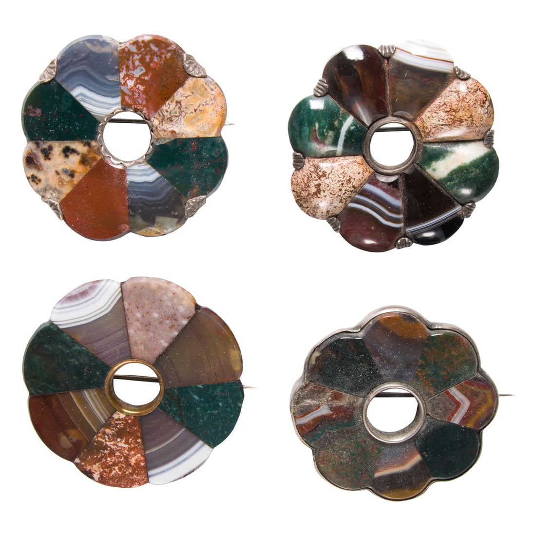 Four hardstone and silver brooches: Four hardstone and silver brooches Of similar design, set with a variety of hardstones including agate; gross weight: 103.00 grams