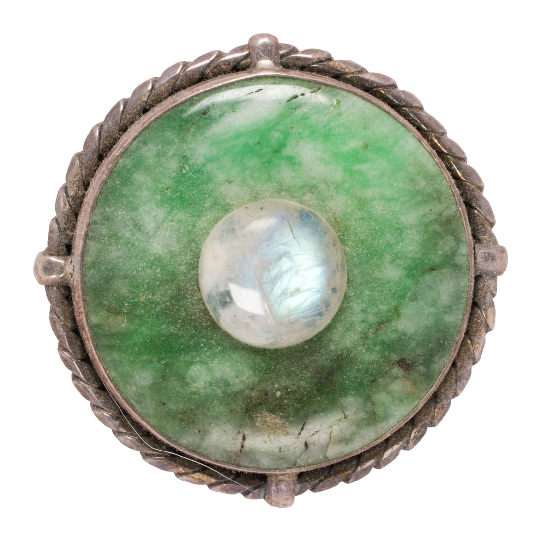 A hardstone and sterling silver brooch: A hardstone and sterling silver brooch Designed as a disc of dyed green hardstone, centering a round-shaped moonstone cabochon measuring 14.80 mm across; width: 2 in; 41.15 grams