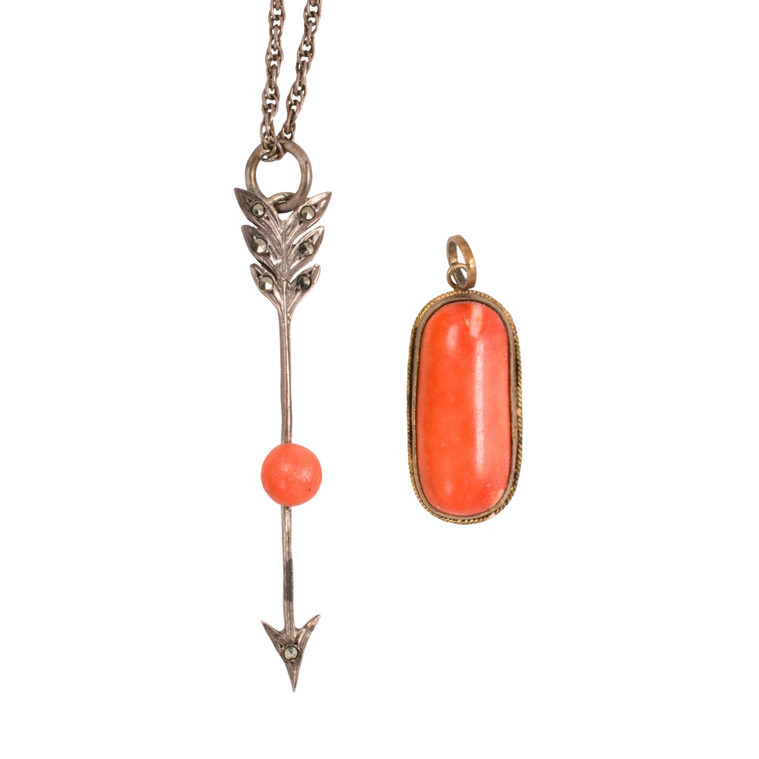 An antique coral pendant necklace and pendant: An antique coral pendant necklace and pendant The silver pendant necklace designed as an arrow, set with one button shaped coral cabochon measuring 6.44 mm, together with a pendant set with an oval-sh