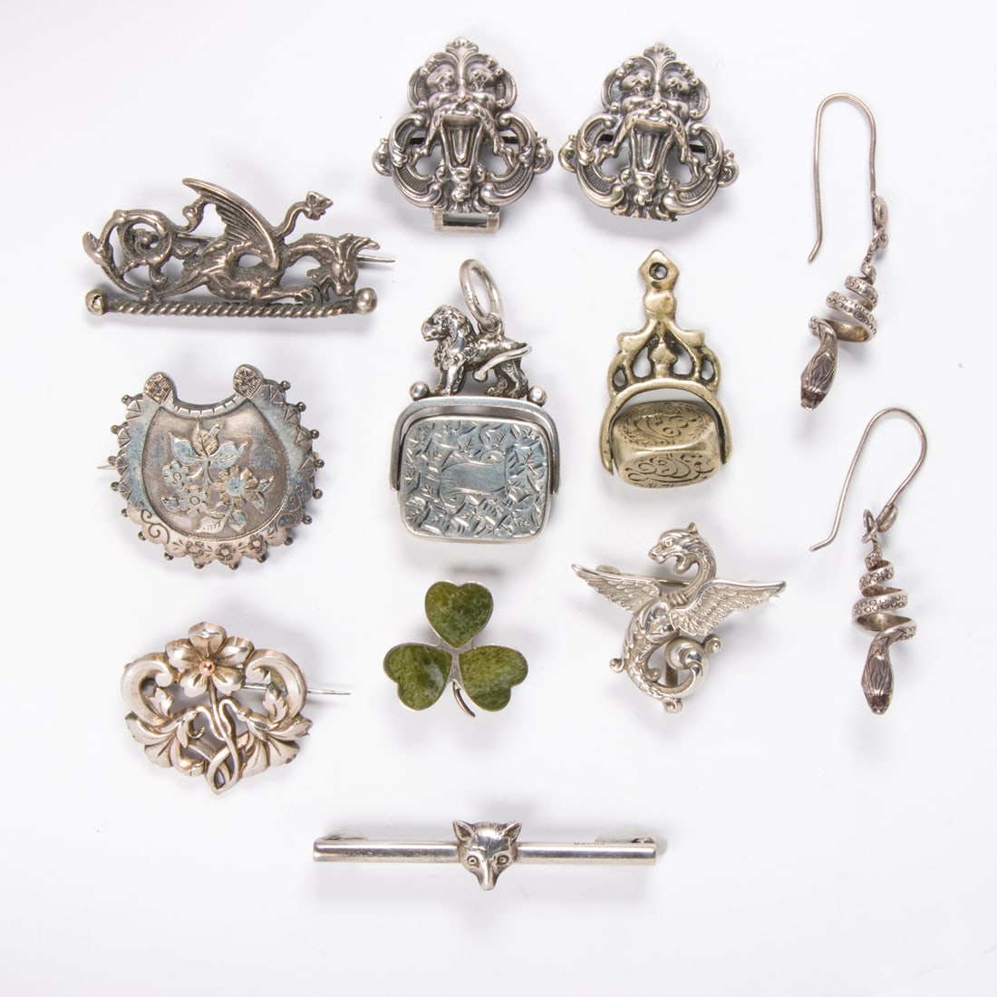 A group of miscellaneous antique silver jewelry: A group of miscellaneous antique silver jewelry Comprising an assortment of antique silver jewelry of varying styles and designs including pins and watch fobs; 45.55 grams